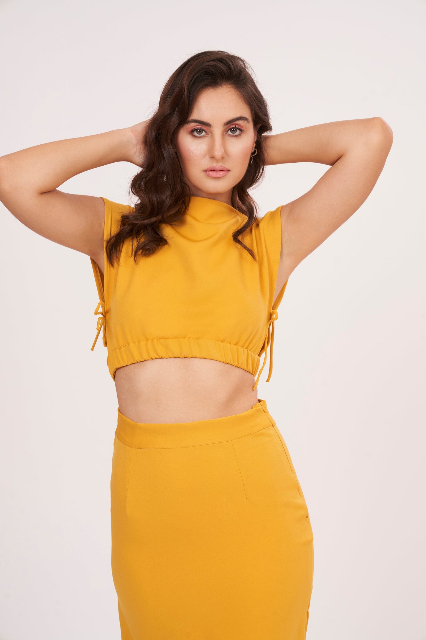 Mustard yellow long skirt with high-waisted design and side slit, made from high-quality muslin fabric. Side cut adds drama and allure. Suitable for dressing up or down.