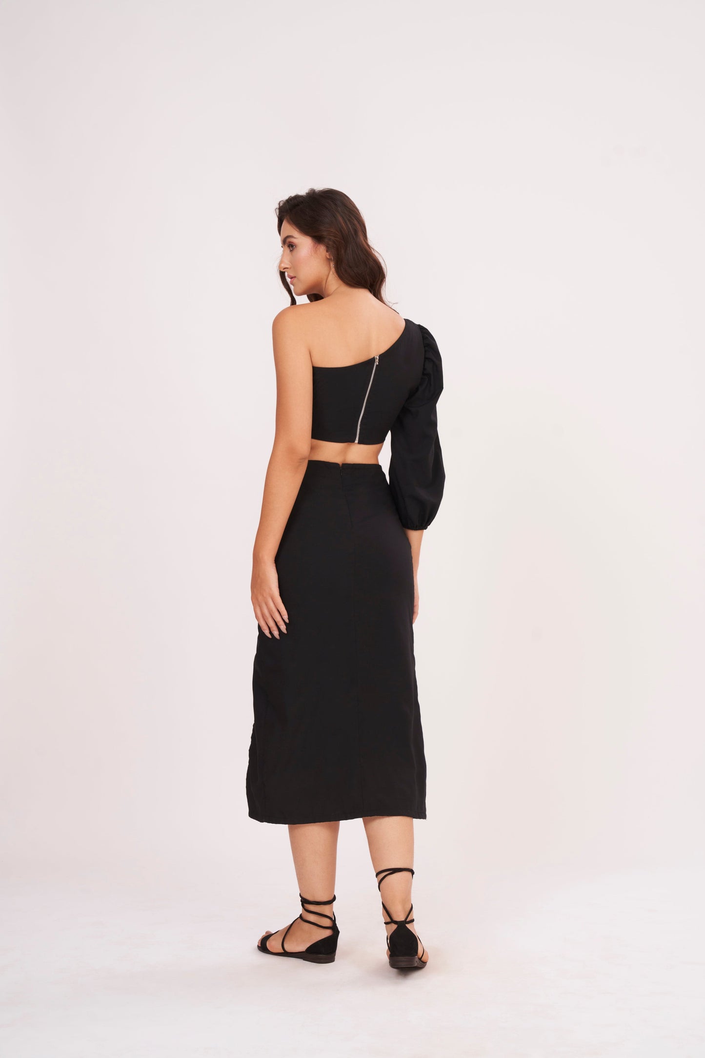 Elegant one-sleeve black top with asymmetrical design, draping across chest and shoulder, made from luxurious muslin fabric