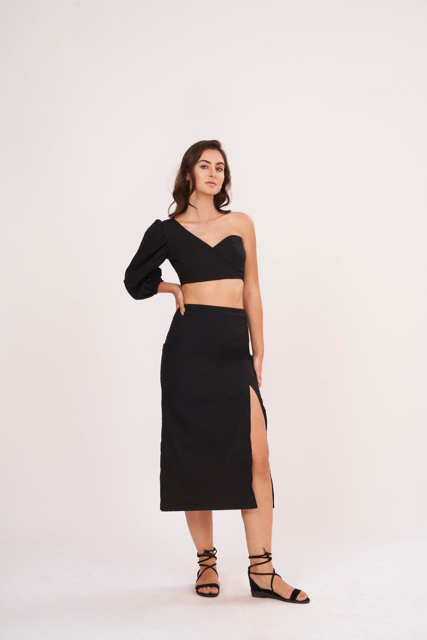 Elegant one-sleeve black top with asymmetrical design, draping across chest and shoulder, made from luxurious muslin fabric