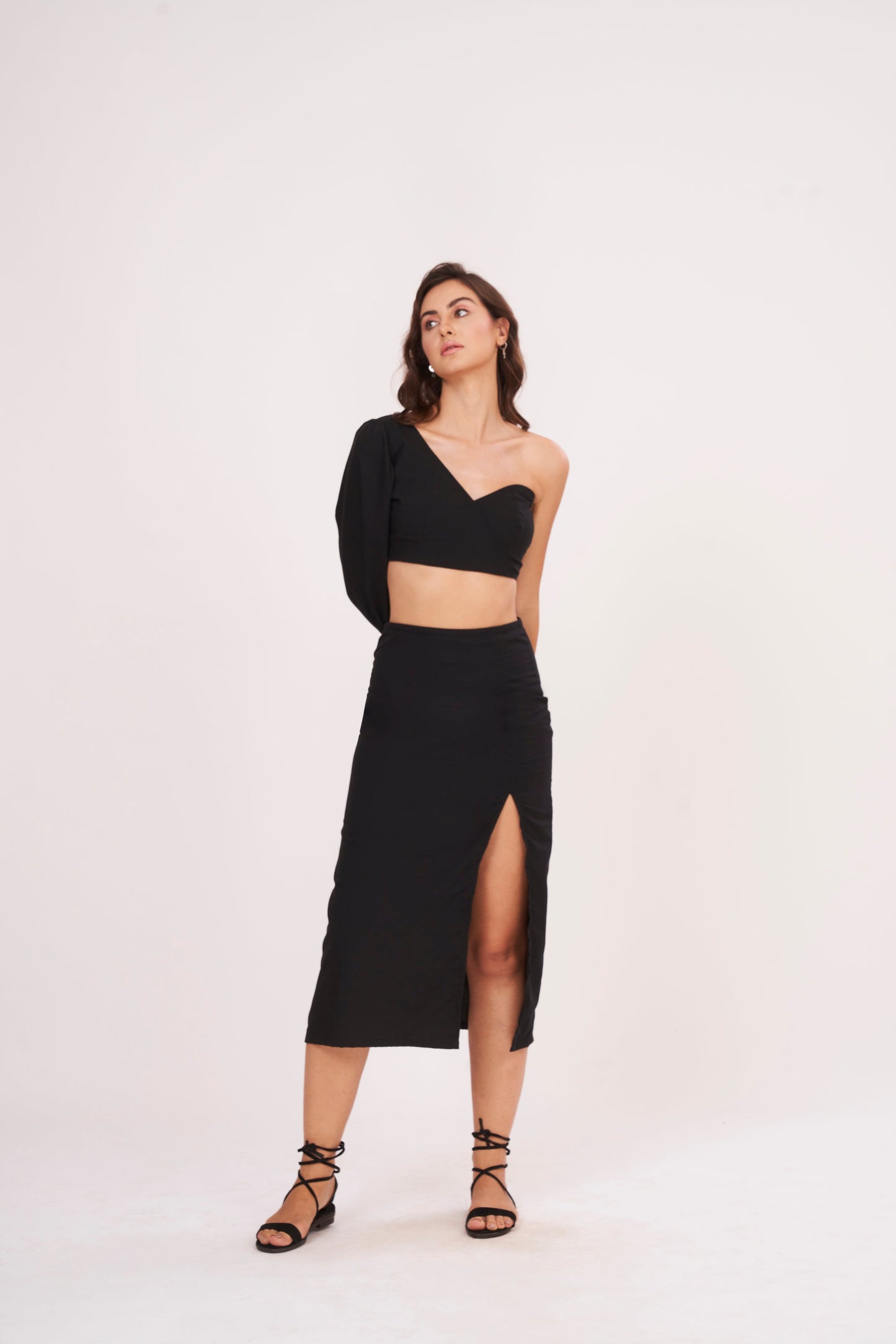 Elegant one-sleeve black top with asymmetrical design, draping across chest and shoulder, made from luxurious muslin fabric