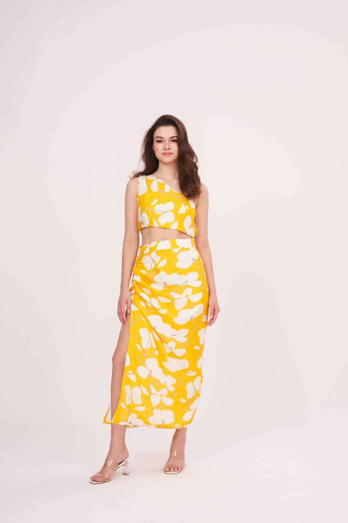 Stylish long skirt with vibrant yellow floral print, perfect for summer. Flattering waist cut creates stunning silhouette, while slit adds touch of elegance.
