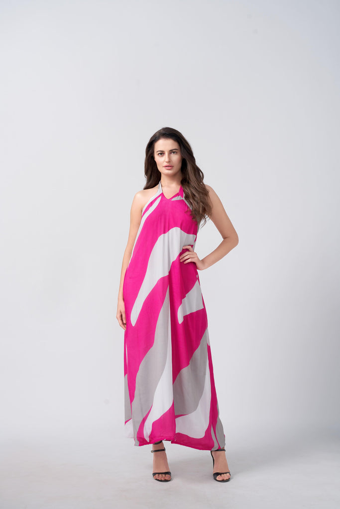Model wearing a pink and white abstract print Chinnon halter dress, standing with one hand on the waist to highlight the relaxed, flowy silhouette.