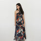 Flowy bohemian halter neck maxi dress featuring navy, olive, beige, and orange abstract pattern