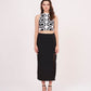 Relaxed standing pose with arms down, showcasing the high slit and length of the black solid skirt.