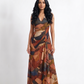 Elegant ankle-length Chinon maxi dress with a halter neckline, ruched bodice, and flowing A-line silhouette in a warm abstract earthy print.