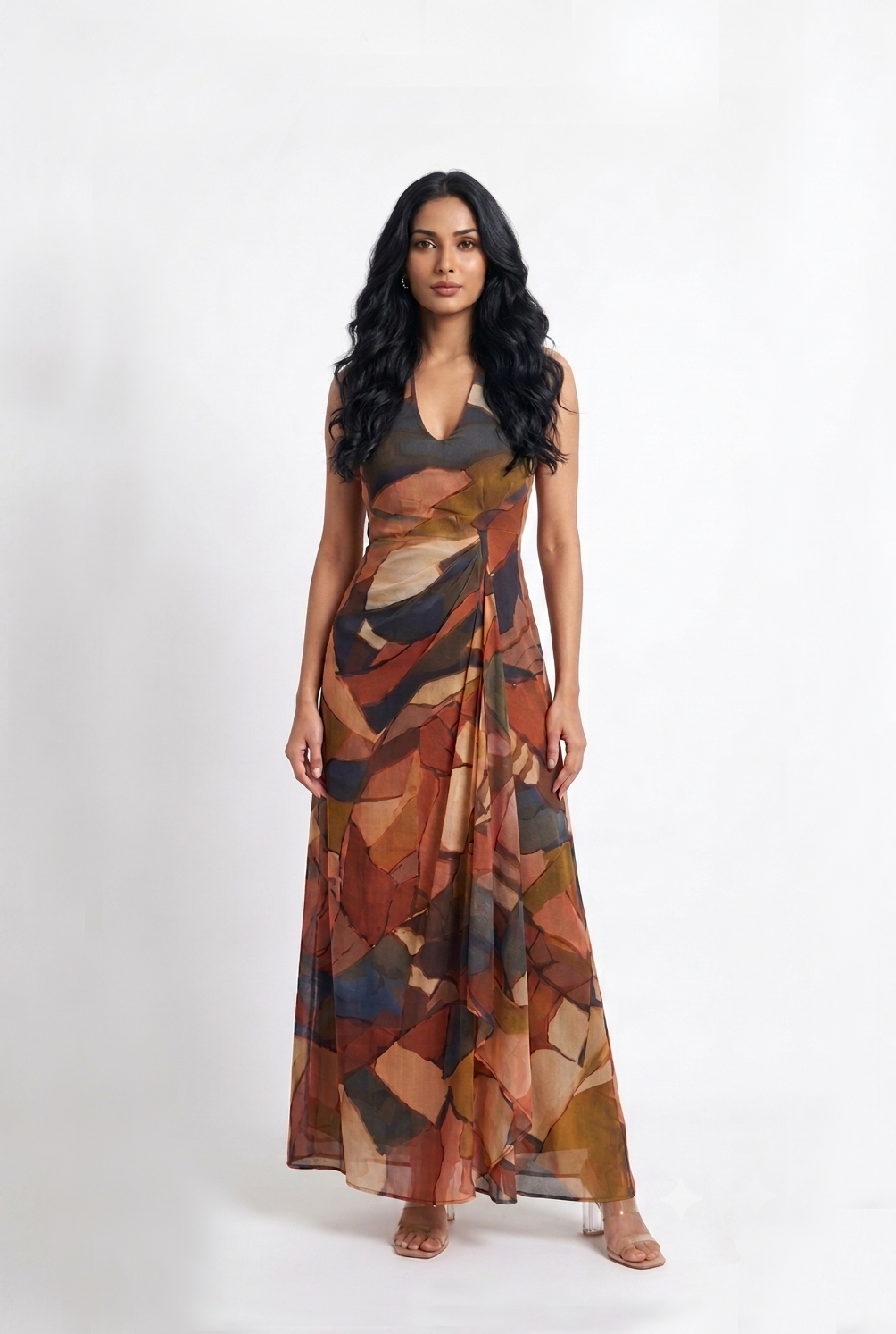 Elegant ankle-length Chinon maxi dress with a halter neckline, ruched bodice, and flowing A-line silhouette in a warm abstract earthy print.