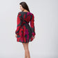 Rear side view of model in red and pink dress with long puff sleeves and a short hemline.