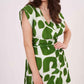 Side profile of green abstract sleeveless wrap dress with V-neck and cinched waist.
