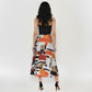 Back view of a sleeveless midi dress featuring a clean-lined black corset-style top and a flowing, multi-colored abstract print skirt.