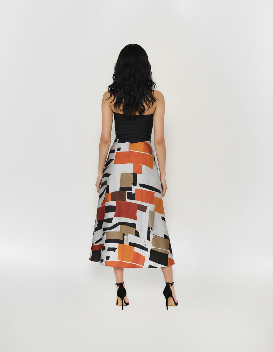 Back view of a sleeveless midi dress featuring a clean-lined black corset-style top and a flowing, multi-colored abstract print skirt.