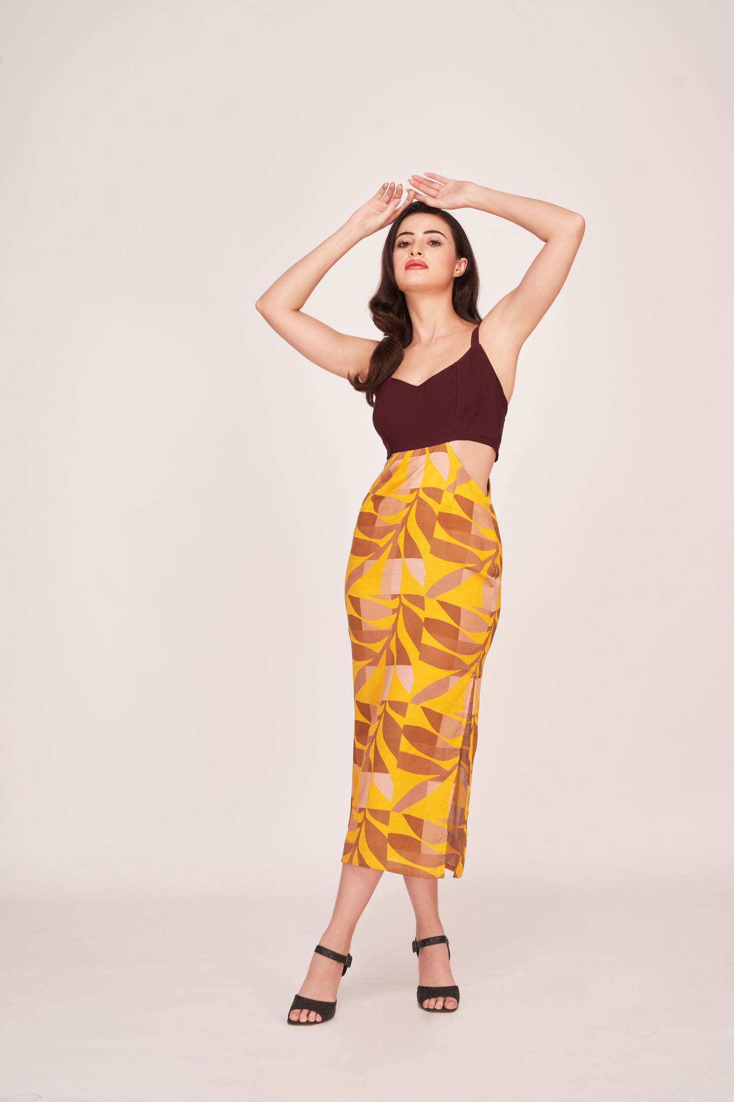Model standing with both hands on top of her head, showcasing the full front view and fitted silhouette of the dress.