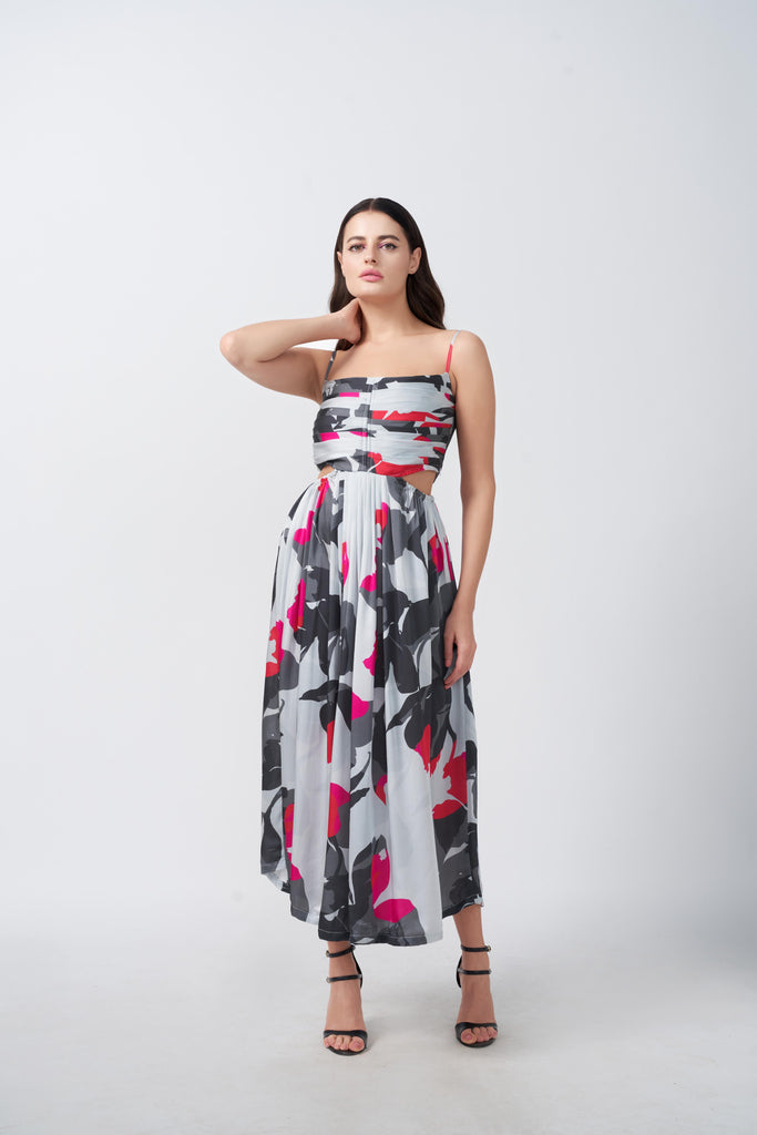 Model in grey, pink, and charcoal abstract print midi dress, posing with one hand near face in studio.