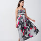Side view of model twirling in pink and grey abstract midi dress, highlighting fluid A-line silhouette.