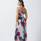 Side-back studio view of model wearing abstract print midi dress with defined waist cuts and flow.
