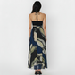 Ankle-length crepe halter dress with a tie-back neckline, featuring a flowing silhouette and a navy blue and olive abstract floral print for a refined, contemporary look.