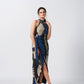 Model standing in full-length view of wrap style crepe dress with high halter neckline and geometric print.