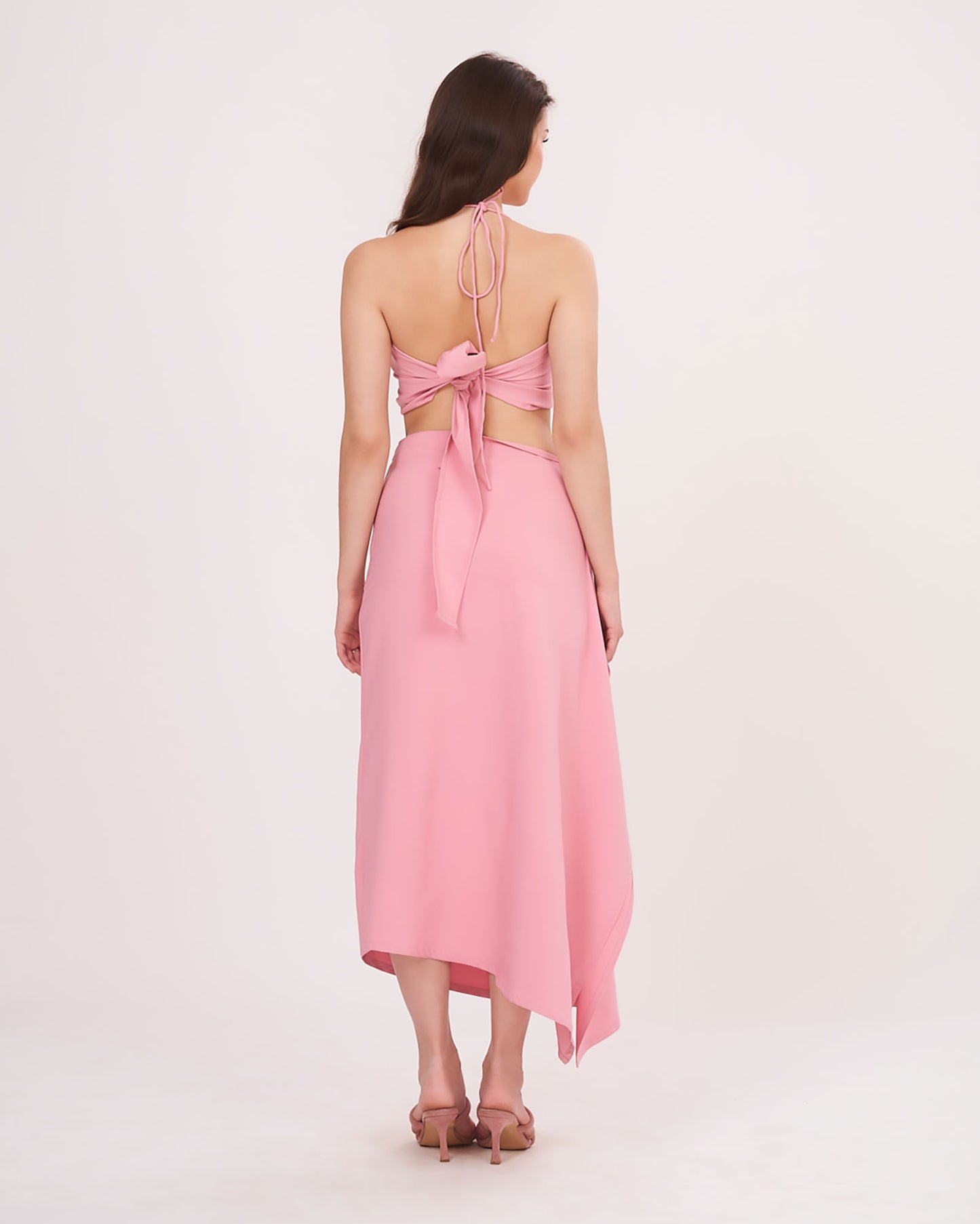 Rear view showing tie-up detail on the halter top and a clean back fall of the ruched ruffle skirt.
