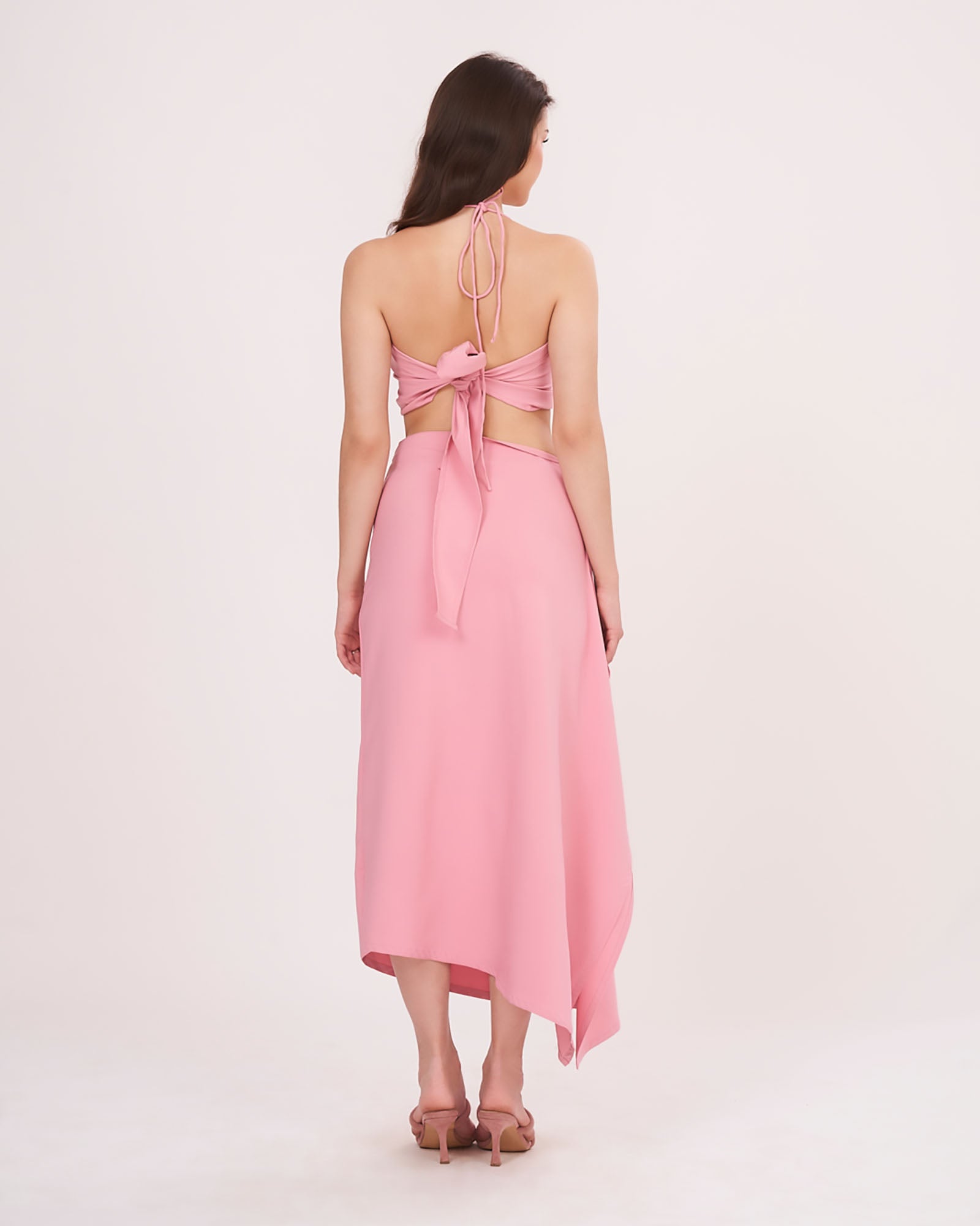 Rear view showing tie-up detail on the halter top and a clean back fall of the ruched ruffle skirt.
