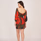 Rear view of the satin floral mini dress showing puffed sleeves, off-shoulder design, and back zip closure.