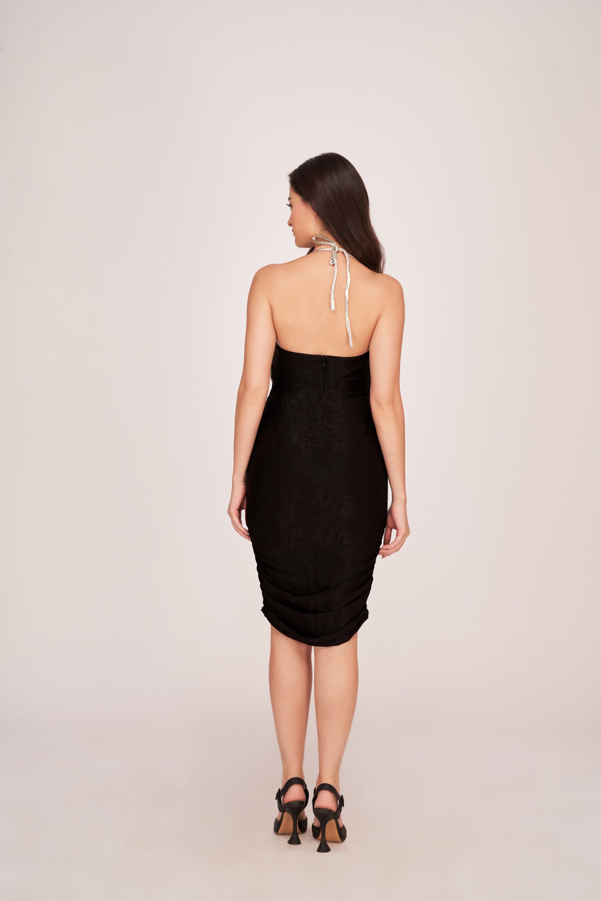 Rear view of the satin black and silver dress highlighting back zip closure and body-hugging fit.