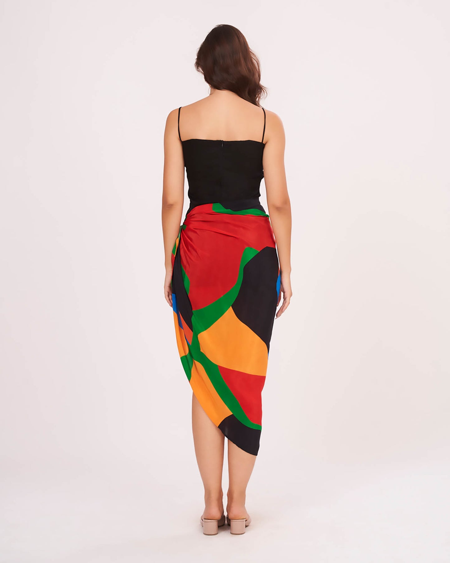 Rear view of the beach co-ord set showing the back zip closure of the black dress and flowy multicolor sarong drape.
