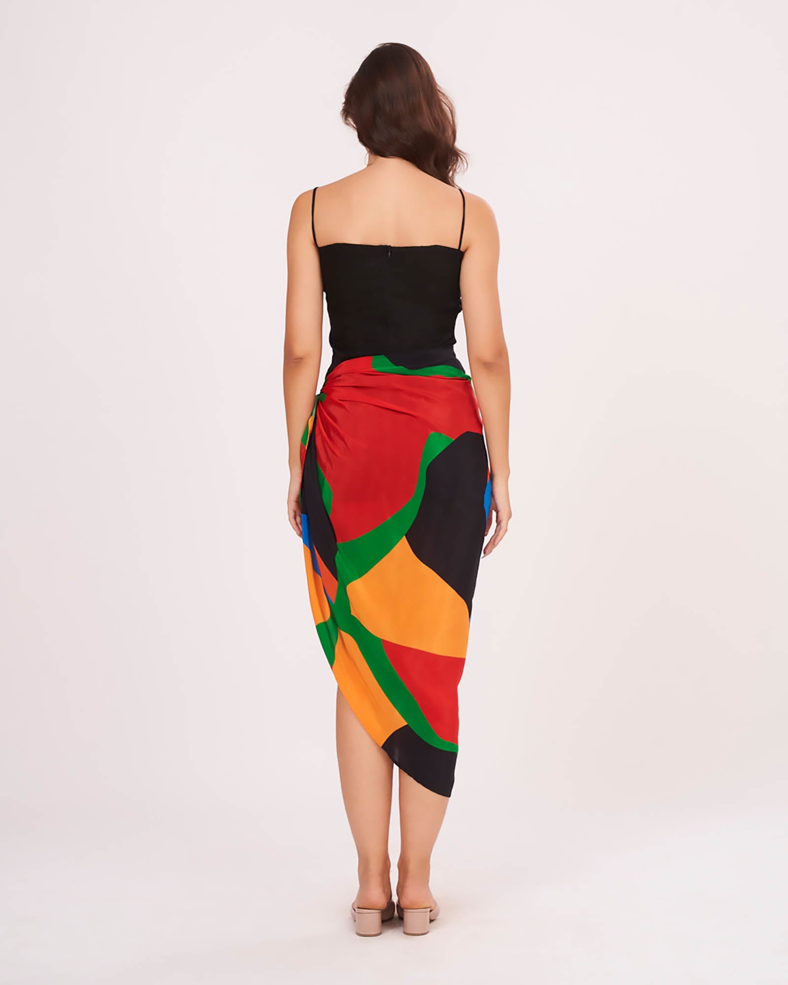 Rear view of the beach co-ord set showing the back zip closure of the black dress and flowy multicolor sarong drape.
