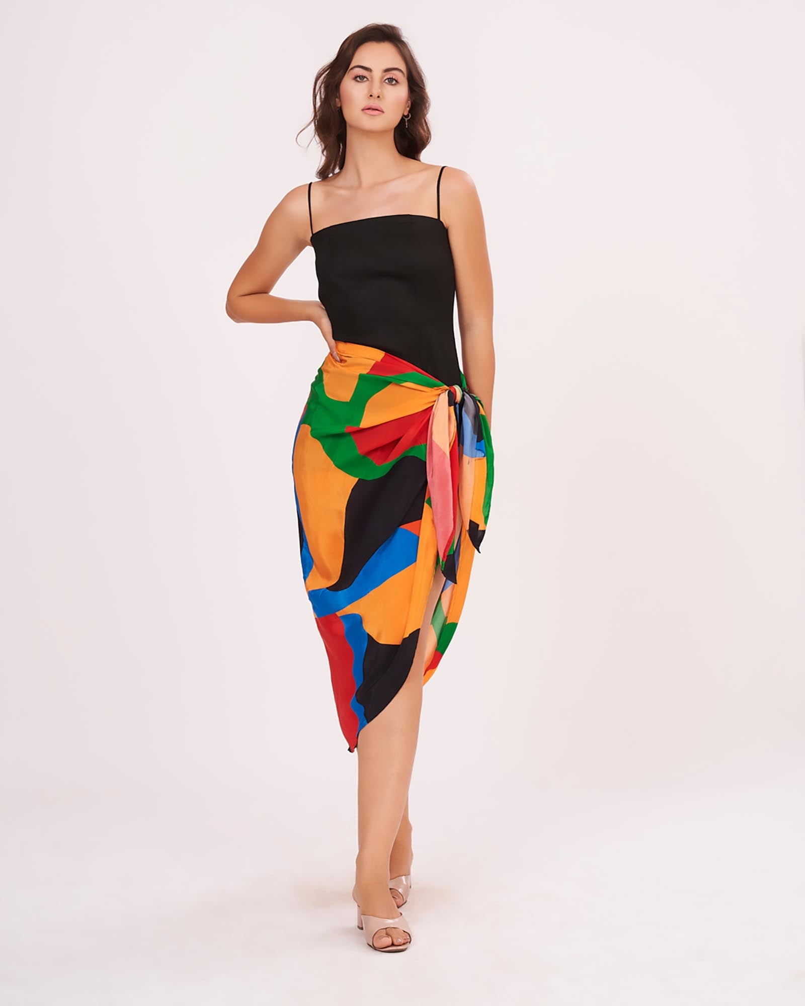 Full frontal standing pose of the model in the beach co-ord set, highlighting the flowy drape of the sarong and sleek black dress.