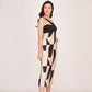 Model posing with one hand on her waist in the black abstract midi dress, highlighting the asymmetric neckline.