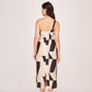 Rear view of the model in the one-shoulder abstract print dress, highlighting the back zip closure and silhouette.