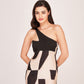 Model standing with hands on waist in studio, displaying front view of the abstract one-shoulder black midi dress.