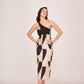Model smiling with relaxed pose in the abstract printed one-shoulder midi dress.