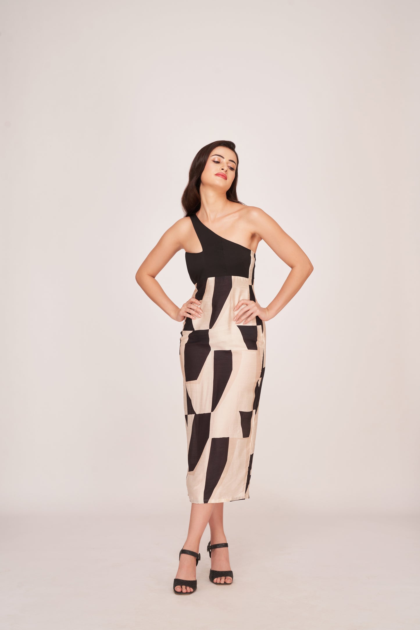 Model smiling with relaxed pose in the abstract printed one-shoulder midi dress.