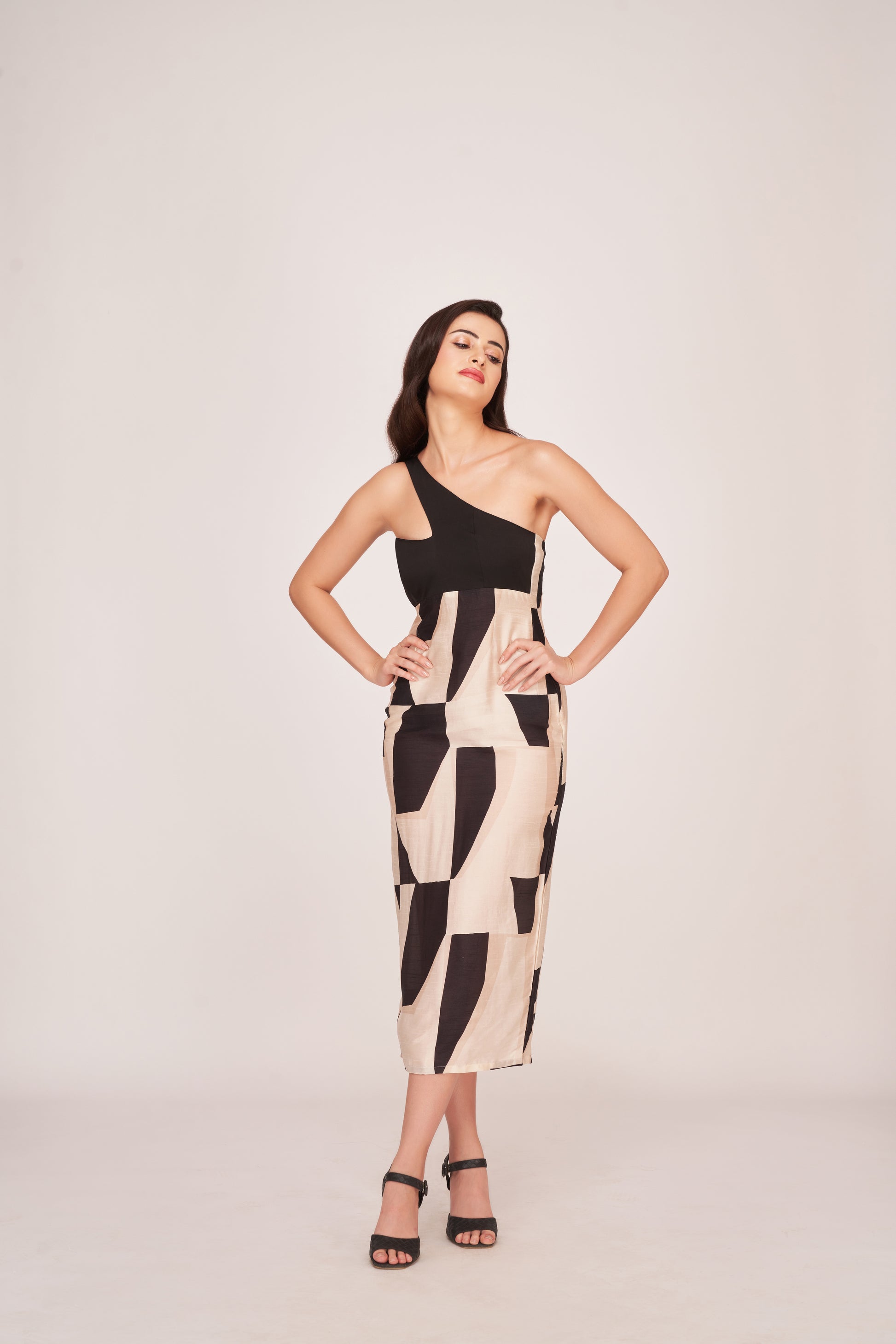 Model smiling with relaxed pose in the abstract printed one-shoulder midi dress.