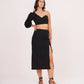Hand-on-waist pose with model smiling, showing the voluminous sleeve and flattering fit of the outfit.