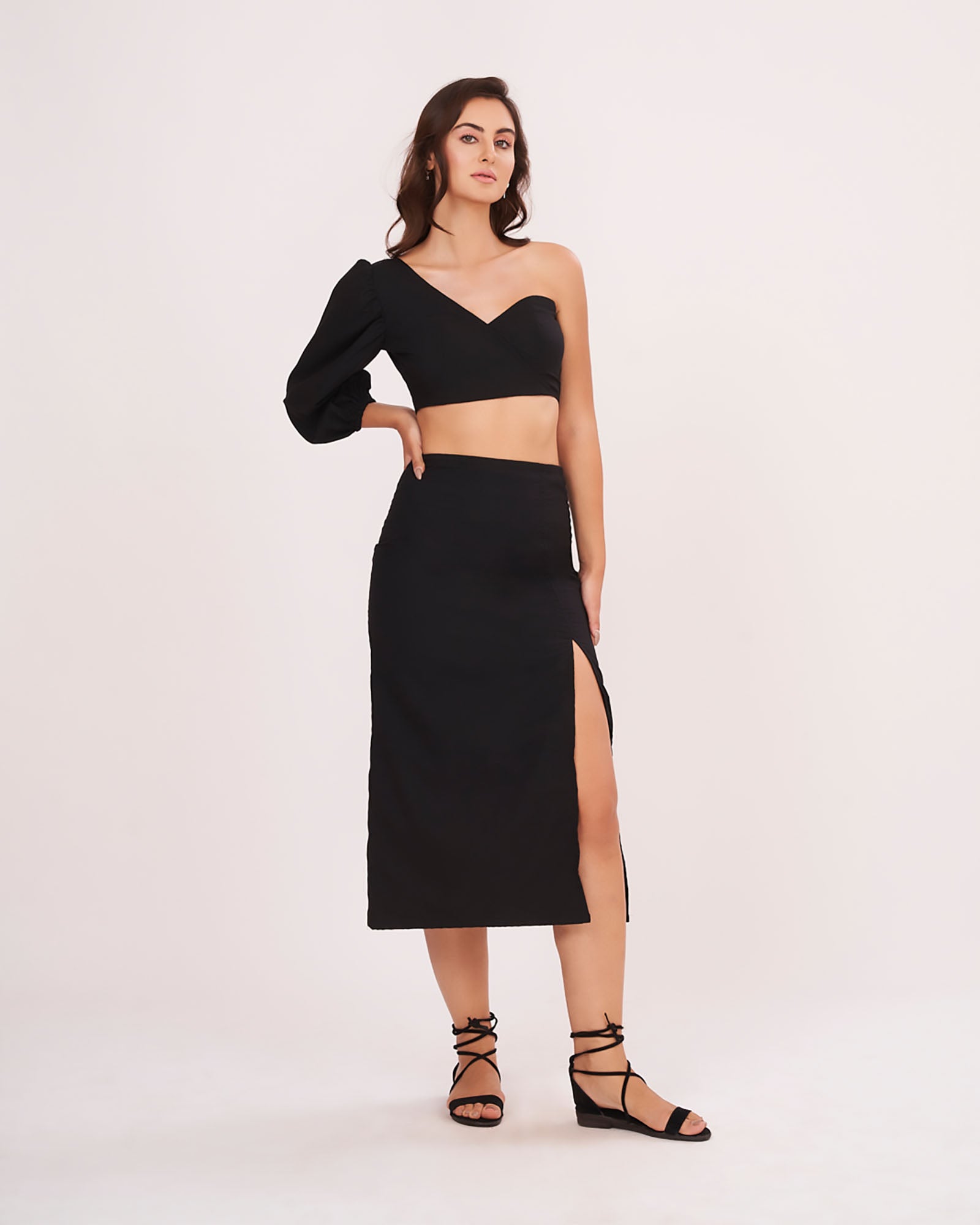 Hand-on-waist pose with model smiling, showing the voluminous sleeve and flattering fit of the outfit.