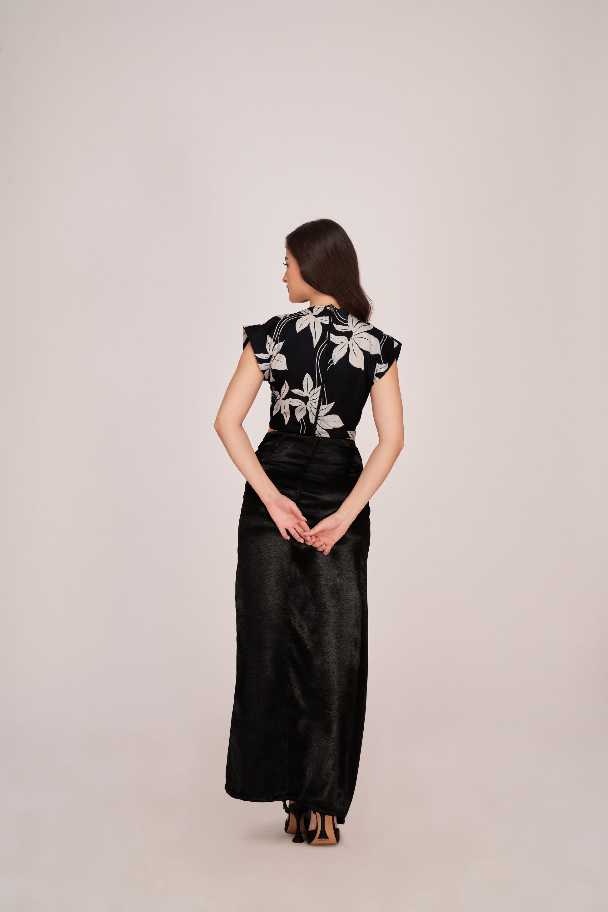 Rear back view of the floral co-ord set, revealing skirt drape and crop top fit from behind with an elegant posture.