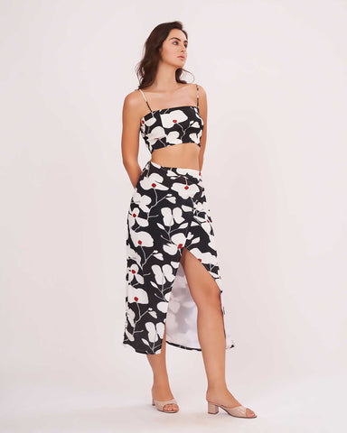 Black floral co-ord set, emphasizing the slit of the printed wrap skirt.