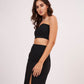 Model in a soft-angled stance showing off the fit of the crop top and the structure of the high-slit skirt.