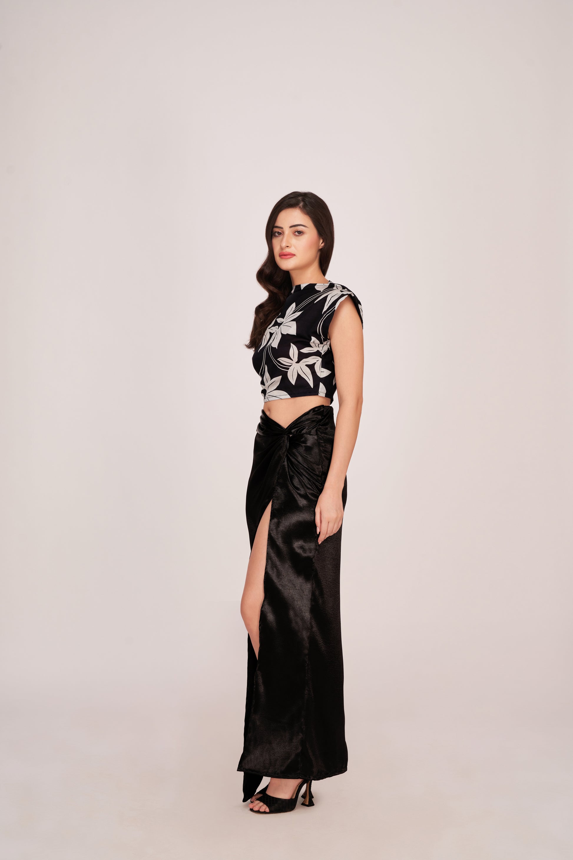 Rear view showing back zip closure and fitted silhouette of the floral crop top paired with the flowing satin skirt.
