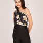 Model in a straight relaxed pose wearing a black floral one-shoulder top and high-waist shorts, highlighting the elegant asymmetry and clean silhouette.