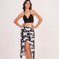 Black halter-neck crop top paired with a midi skirt featuring a bold white floral print on a black background.