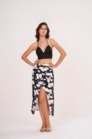 Black halter-neck crop top paired with a midi skirt featuring a bold white floral print on a black background.