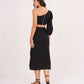Rear view displaying the back zip closure and full-length flow of the solid black skirt.