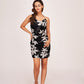 Full front view of the black printed satin dress with spaghetti straps and big white floral detailing.