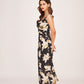 Model walking away in the black floral satin dress, offering a flowing back view and elegant stride.