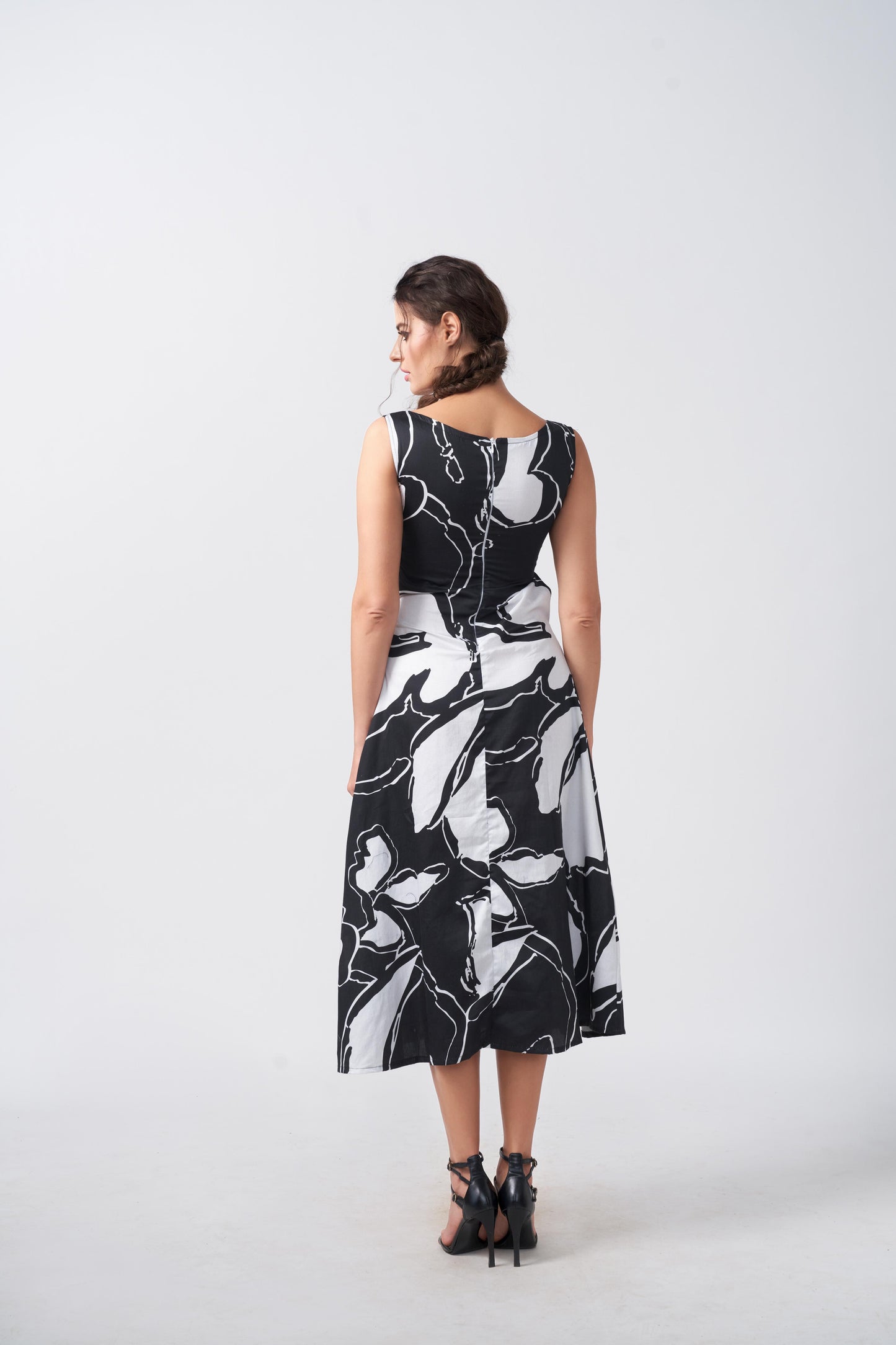 Back view of model in black and white abstract cut-out dress, capturing the modern silhouette and flow