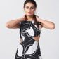 Close-up of model adjusting neckline, showcasing the black and white floral print and shoulder design.