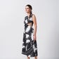 Side view of the model walking in sleeveless black and white abstract dress, highlighting the waist cut-out detail.