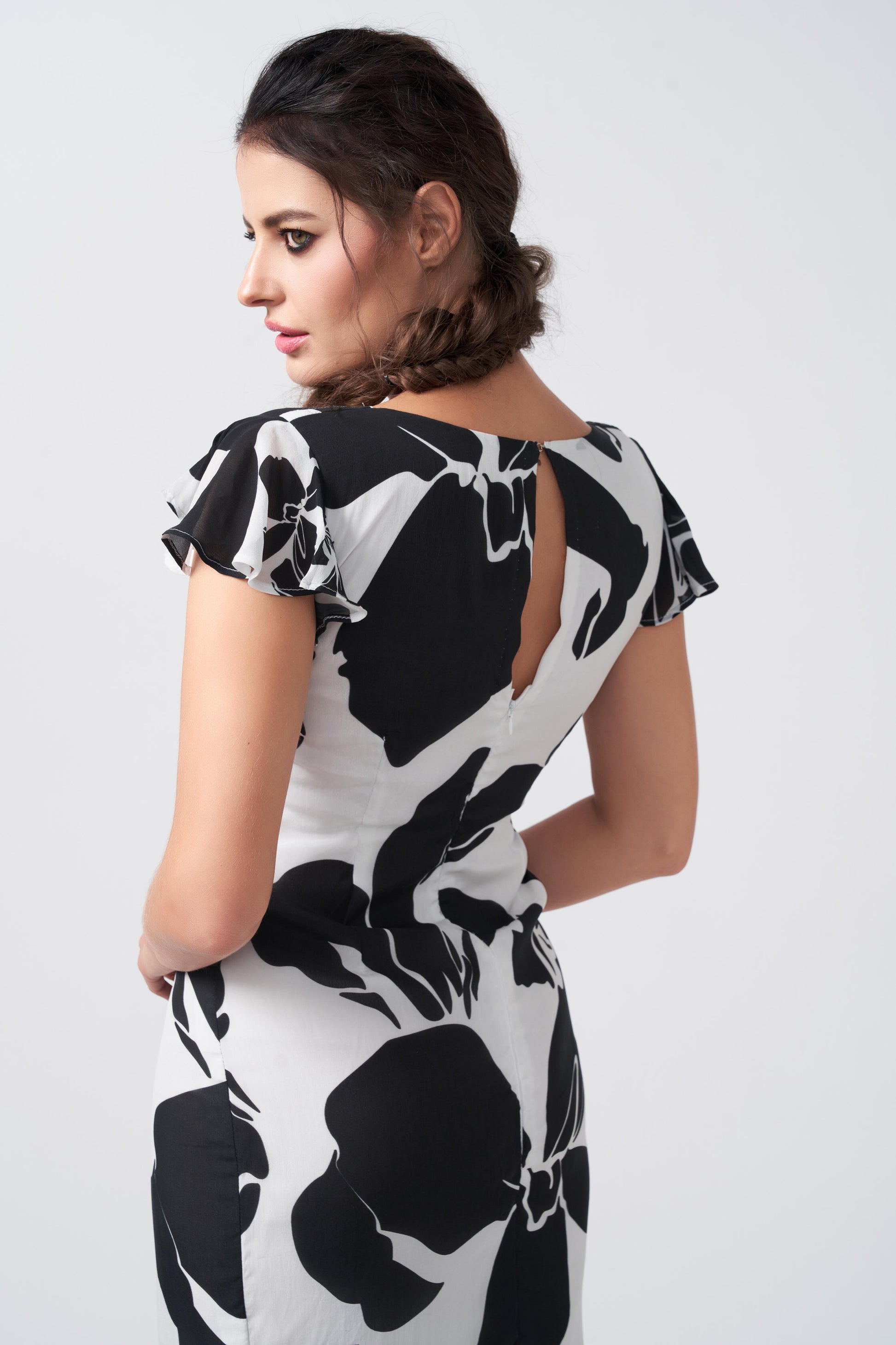 Close-up of ruffle sleeves and V-neckline in the black and white floral dress.