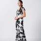 Side angle of the model in black and white abstract floral dress, highlighting elegant drape.